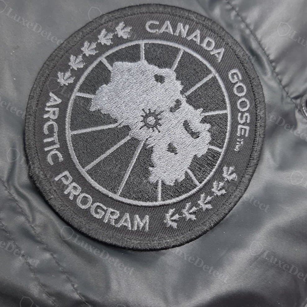 Écusson de manche d'un manteau confirmé contrefait : un écusson gris ton sur ton. Le coloris seul ne prouve rien, car les manteaux Black Label authentiques portent un écusson noir, gris et blanc ; jugez plutôt la broderie et les lettres.
