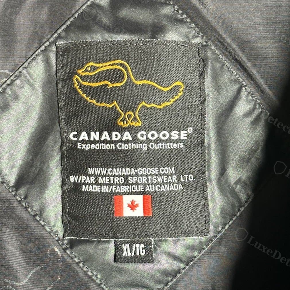 Interior label on a coat confirmed counterfeit: a gold outline goose and "Expedition Clothing Outfitters" wordmark. This older label design also appears on genuine pre-2011 coats, so the design alone is not a tell; it has to match the coat's era and the rest of the checks.