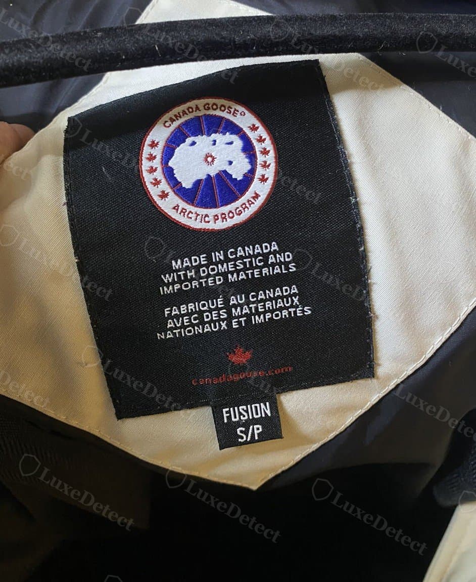 Etiqueta interior original: el emblema negro tejido del Arctic Program sobre "MADE IN CANADA WITH DOMESTIC AND IMPORTED MATERIALS" en inglés y francés, con una etiqueta de talla aparte debajo.