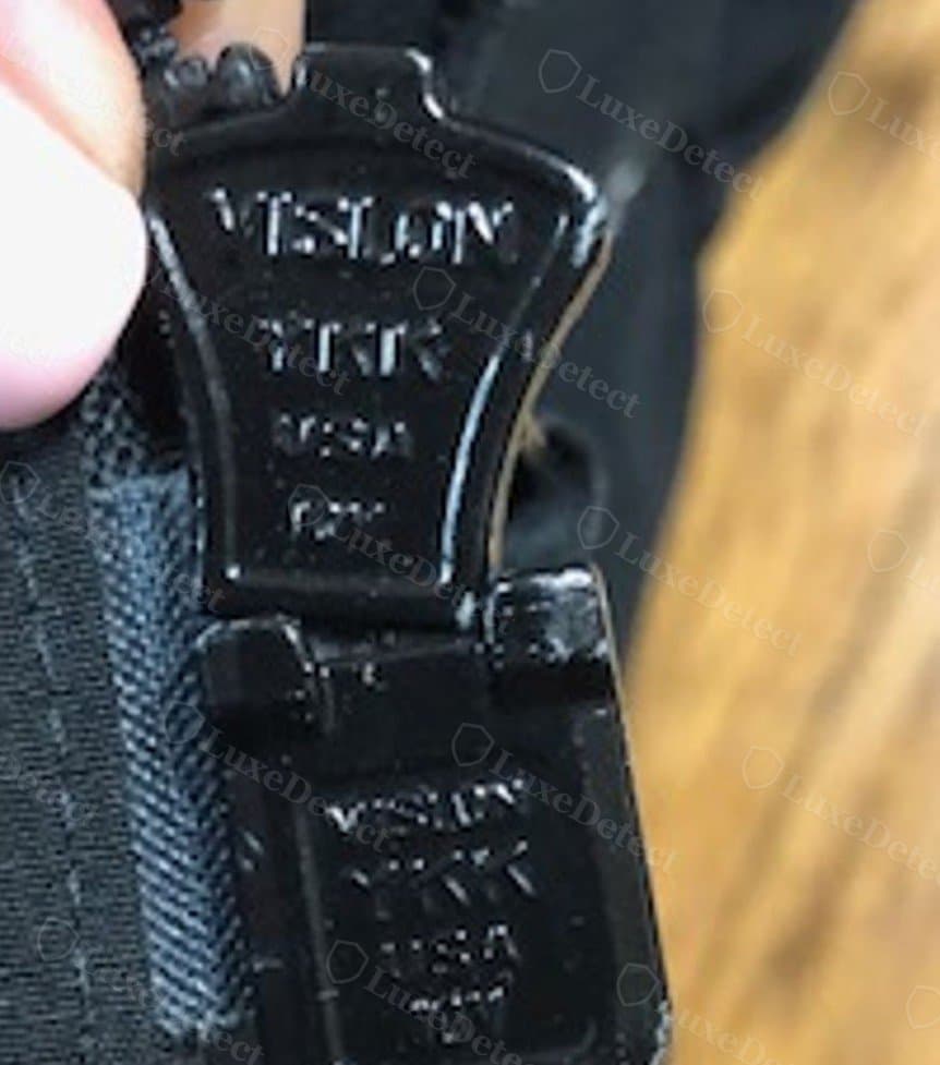 Cursor de zíper autêntico: a ferragem de metal Vislon traz “VISLON YKK USA” estampado diretamente no cursor.