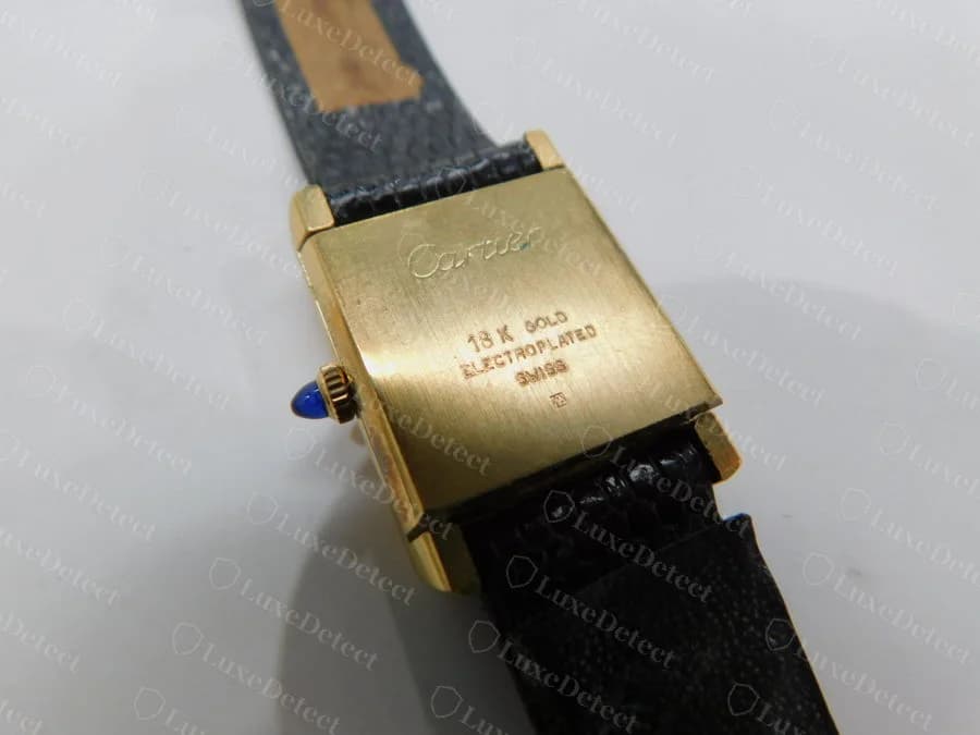 The engraved back of a genuine vermeil Must de Cartier Tank: Cartier signature, 18K gold electroplated and Swiss, with no serial visible in this view