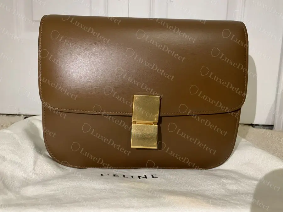 Counterfeit Classic Box photographed on a dust bag with the post-2018 CELINE logo. The bag's own stamps were Philo era. Packaging travels separately from bags and is never proof.