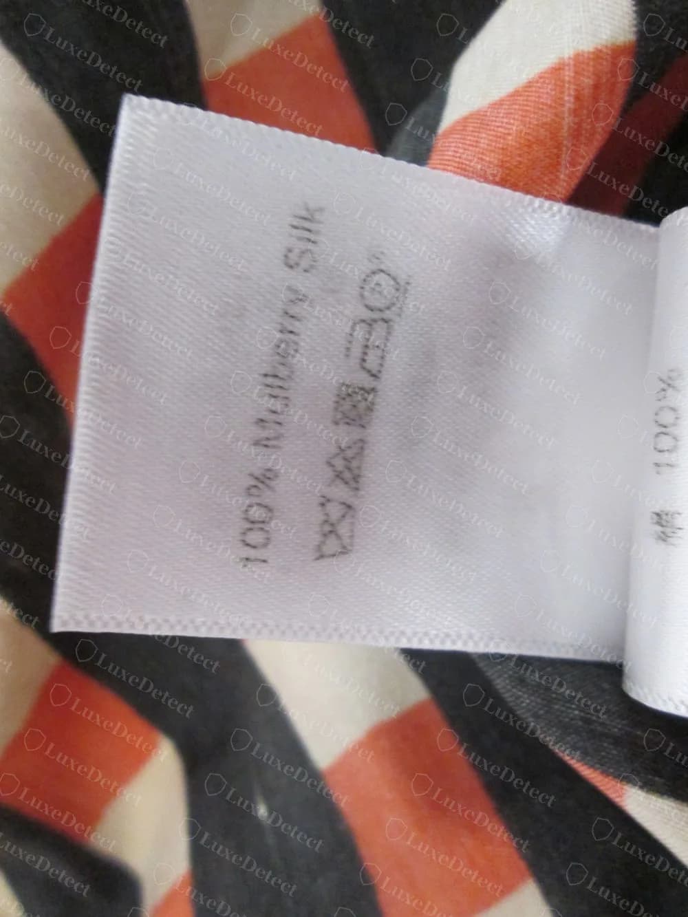 Blusa Celine falsificada: a etiqueta seguinte na mesma peça traz 100% Mulberry Silk