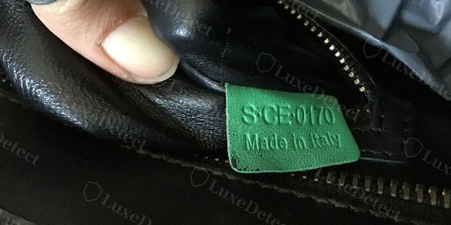 Etiqueta falsificada: cuero granulado verde estampado S·CE·0170 y "Made in Italy". El código está bien formado y se descifra como julio de 2010, una fecha creíble para un Luggage, que es justo la razón por la que un código limpio no prueba nada.