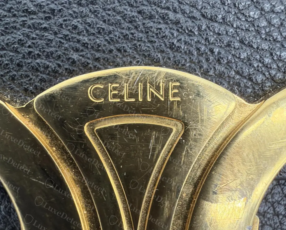 Counterfeit Triomphe clasp (sold as a Teen Triomphe and rejected for engraving quality): the CELINE letters are shallow and read as thin outlines rather than cut recesses.