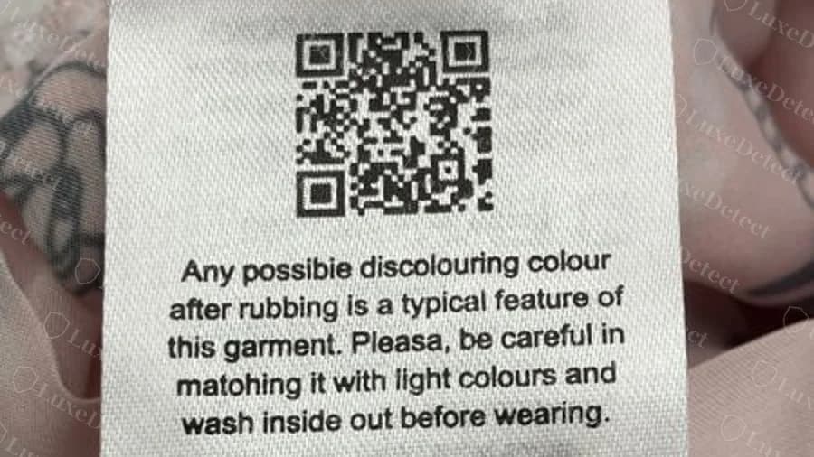 Fake label with a QR code over an English and German notice about colour rubbing, with several misspellings