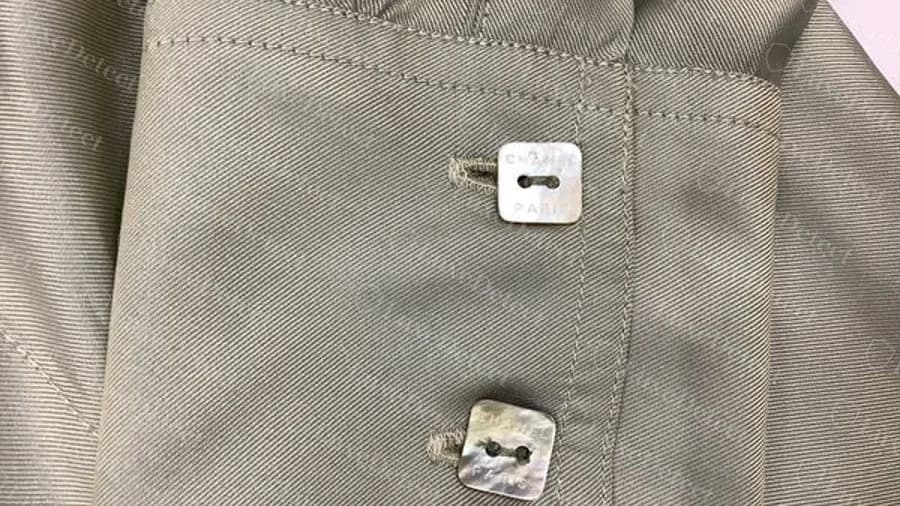 Botones cuadrados de nácar originales de Chanel en un puño de camisa, con CHANEL PARIS estampado