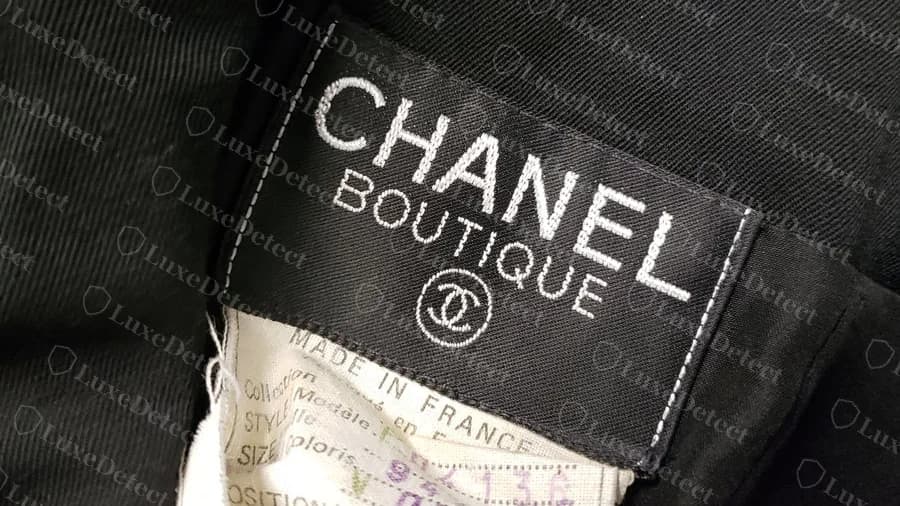Etiqueta tejida Chanel Boutique vintage original encima de una hoja impresa con campos de estilo, talla y composición escritos a mano, MADE IN FRANCE