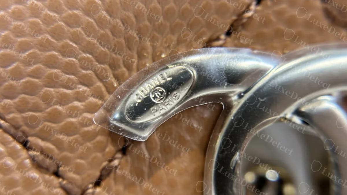 Underside of the CC turnlock on a genuine Coco Handle, with a small CC and CHANEL PARIS engraved on the loop