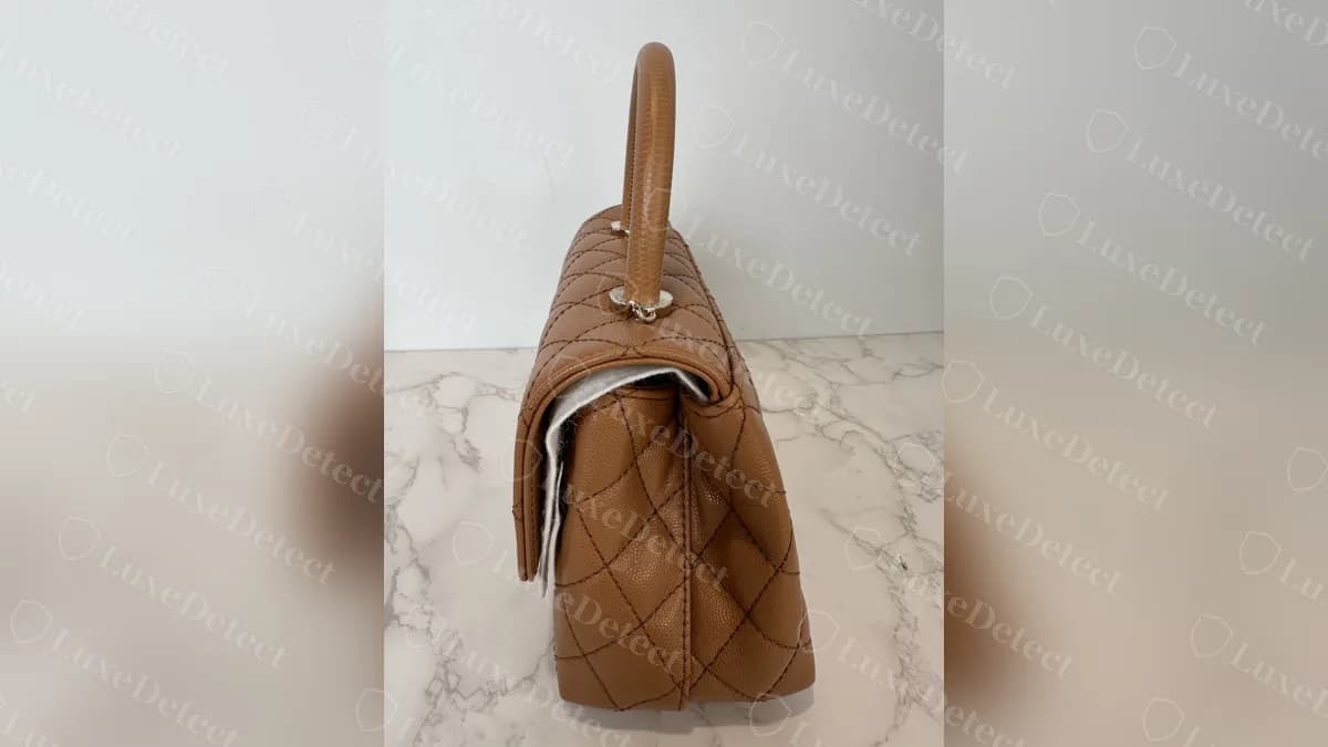 Side profile of a genuine Coco Handle: a rigid upright handle and a structured flap