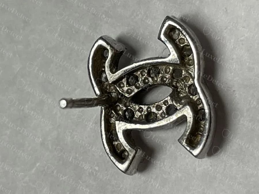 Counterfeit Chanel crystal CC stud earring from the back, an open channel with the undersides of the stones visible