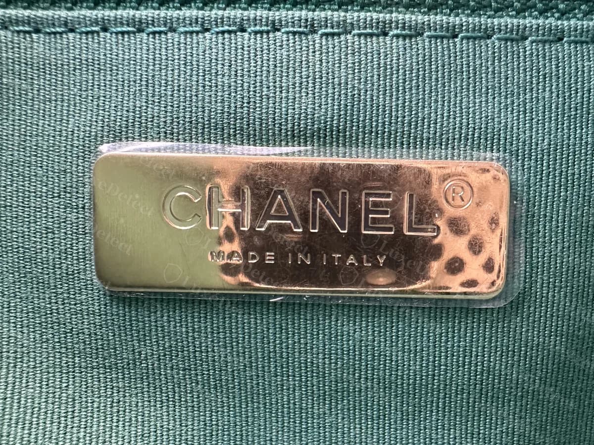 Interior de un Chanel 19 original verde con forro verde: una placa metálica en tono dorado que dice CHANEL y MADE IN ITALY