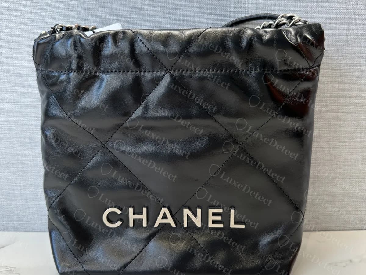 Genuine Chanel 22 Mini in black shiny calfskin with silver-tone hardware: the same soft quilted shape with silver-tone CHANEL letters