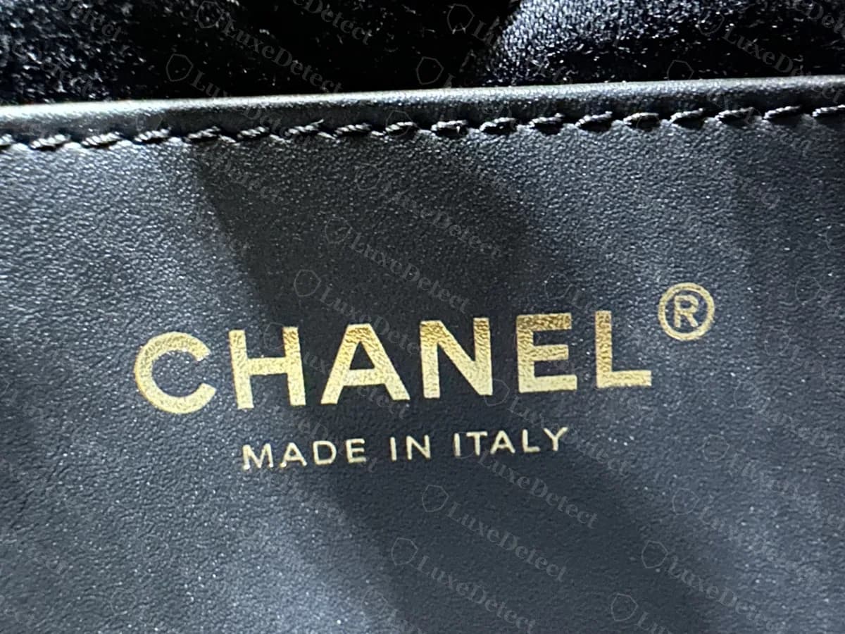 Genuine Chanel 22 interior label: "CHANEL" with the registered mark above "MADE IN ITALY", stamped in gold on black lining