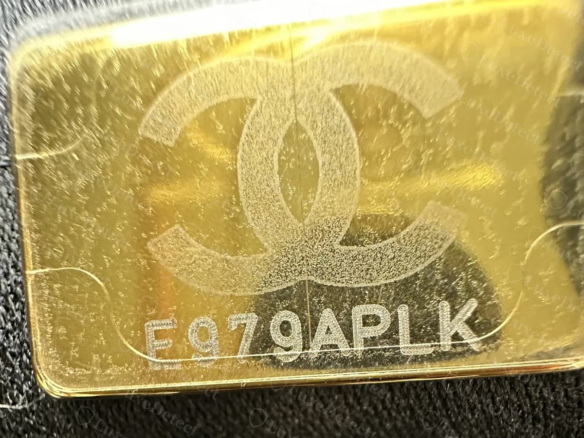 Genuine gold-tone serial plaque inside a Chanel 22: the CC logo above an eight-character code, on black lining