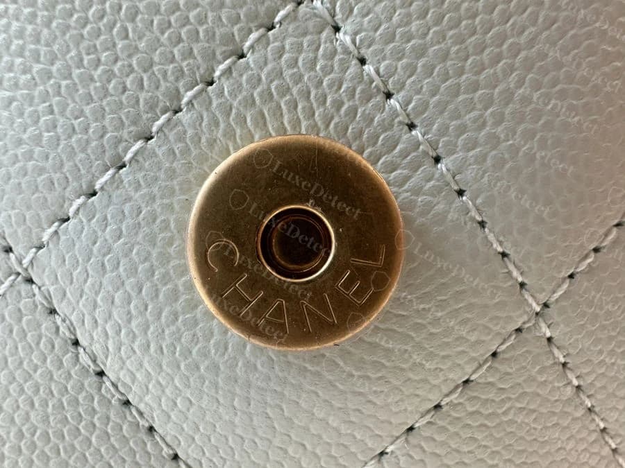 Genuine magnetic snap stamped CHANEL in the house's signature serif typeface, centered and evenly pressed