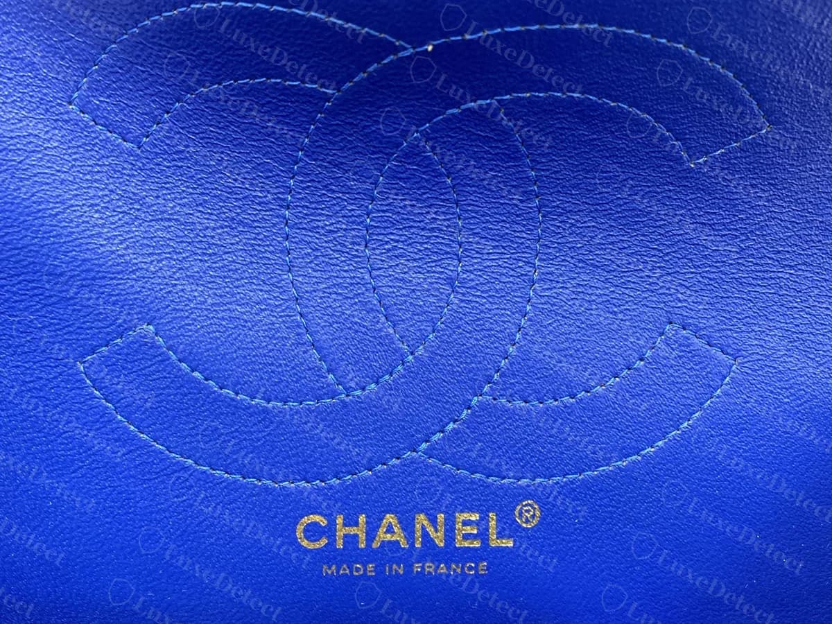 Bolso original con etiqueta de reissue y forro azul intenso: una CC cosida en el bolsillo de la solapa y un sello dorado CHANEL y MADE IN FRANCE