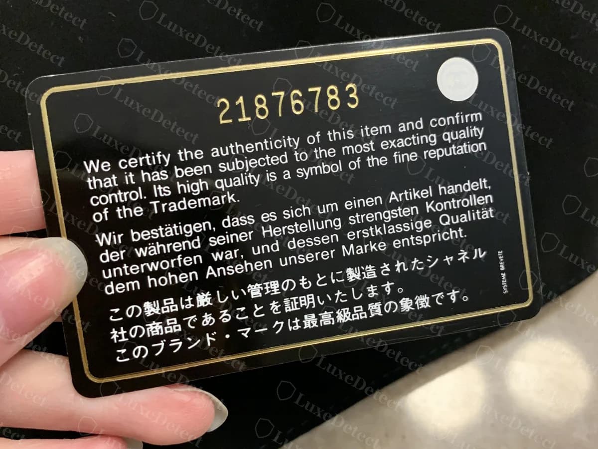 Echte Chanel-Echtheitskarte mit achtstelliger Seriennummer: 21876783 in Gold oben, dreisprachiger Zertifikatstext und rundes CC-Siegel