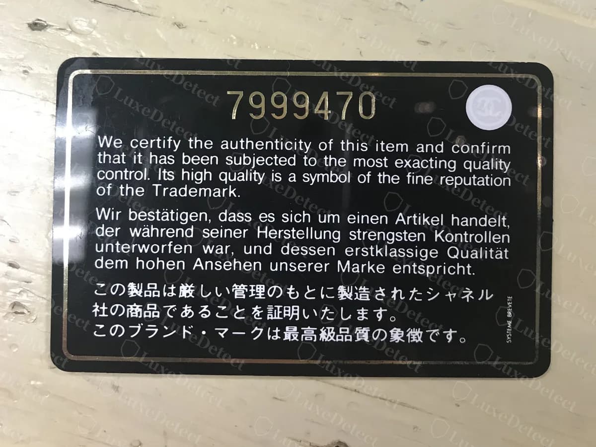 Genuine Chanel authenticity card, back: a gold serial number at the top, the same certification text in English, German and Japanese, a round CC seal at top right and "Système Brevete" printed vertically at the right edge