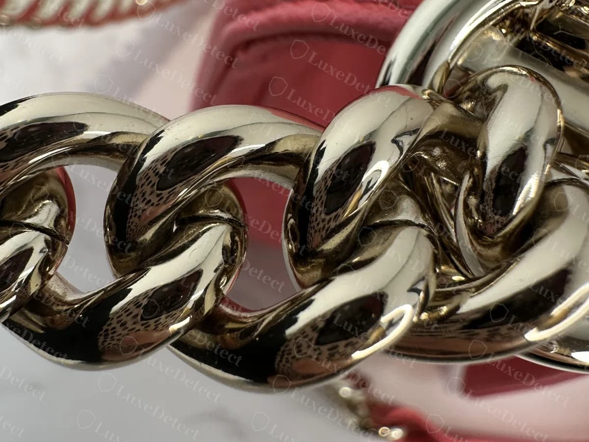 Nahaufnahme der dicken Panzerkettenglieder an einer echten rosa Chevron Boy in Goldton, mit glatten, polierten Gliedern