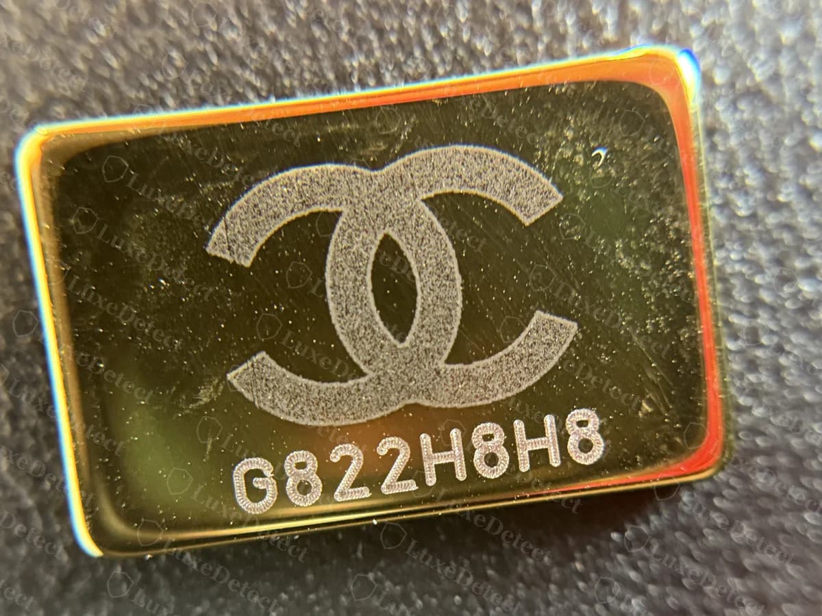Placa en tono dorado original en el forro interior de un Boy reciente: el logo CC encima del código de 8 caracteres G822H8H8