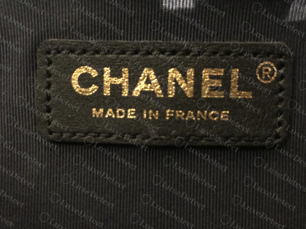 Interior de un Boy original: CHANEL, la marca registrada y MADE IN FRANCE impresos en dorado sobre un parche de tela negro cosido al forro