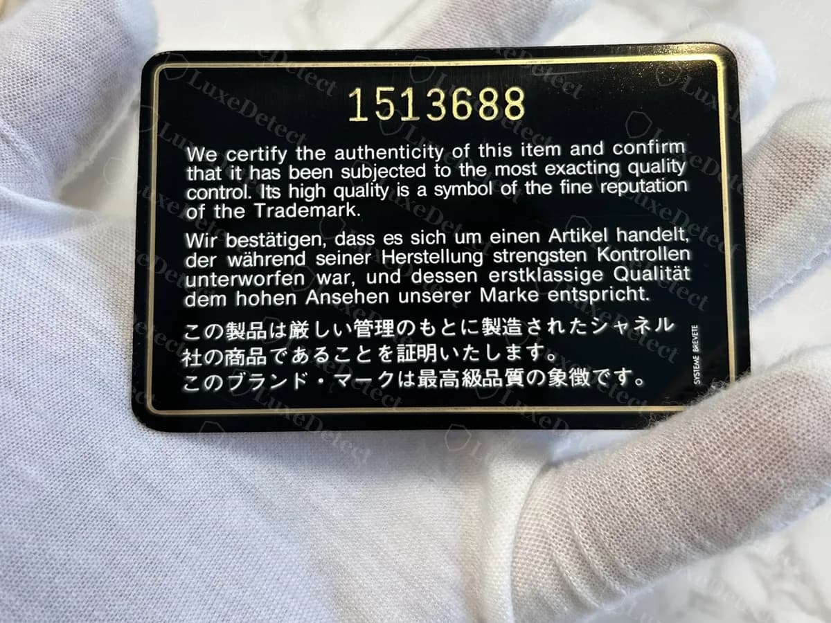Echte Echtheitskarte: schwarz mit Goldrand und der Nummer 1513688 oben, mit dem Text auf Englisch, Deutsch und Japanisch