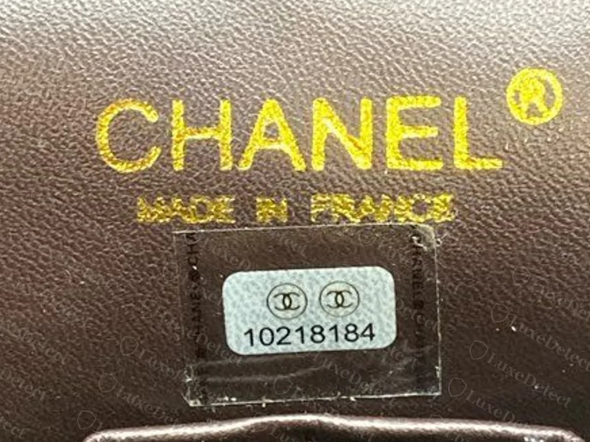 Als Fälschung beurteilte Classic Flap: Der Aufkleber unter seiner durchsichtigen Abdeckung im Inneren der Tasche zeigt 10218184, unter einer goldenen Prägung CHANEL und MADE IN FRANCE