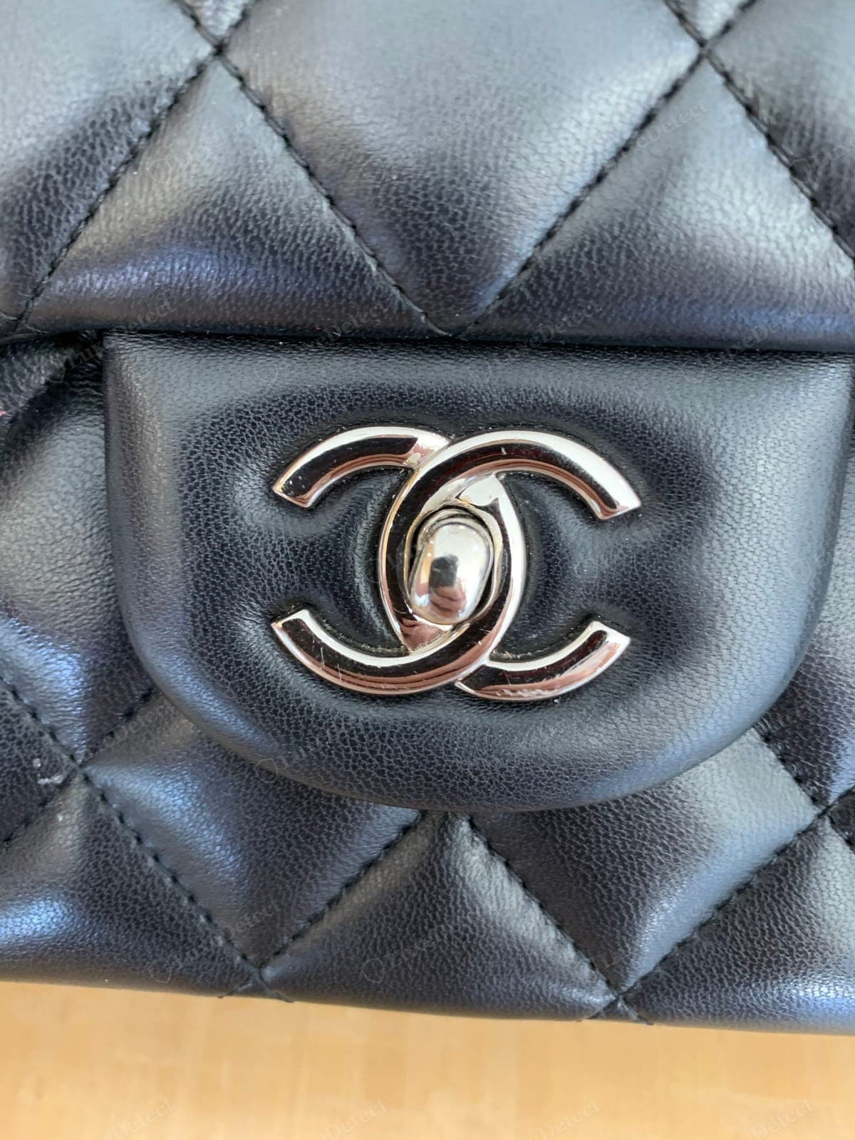 Counterfeit Chanel CC turn-lock — the C overlap reversed or uneven, thin or brassy plating, a loose or vague turn