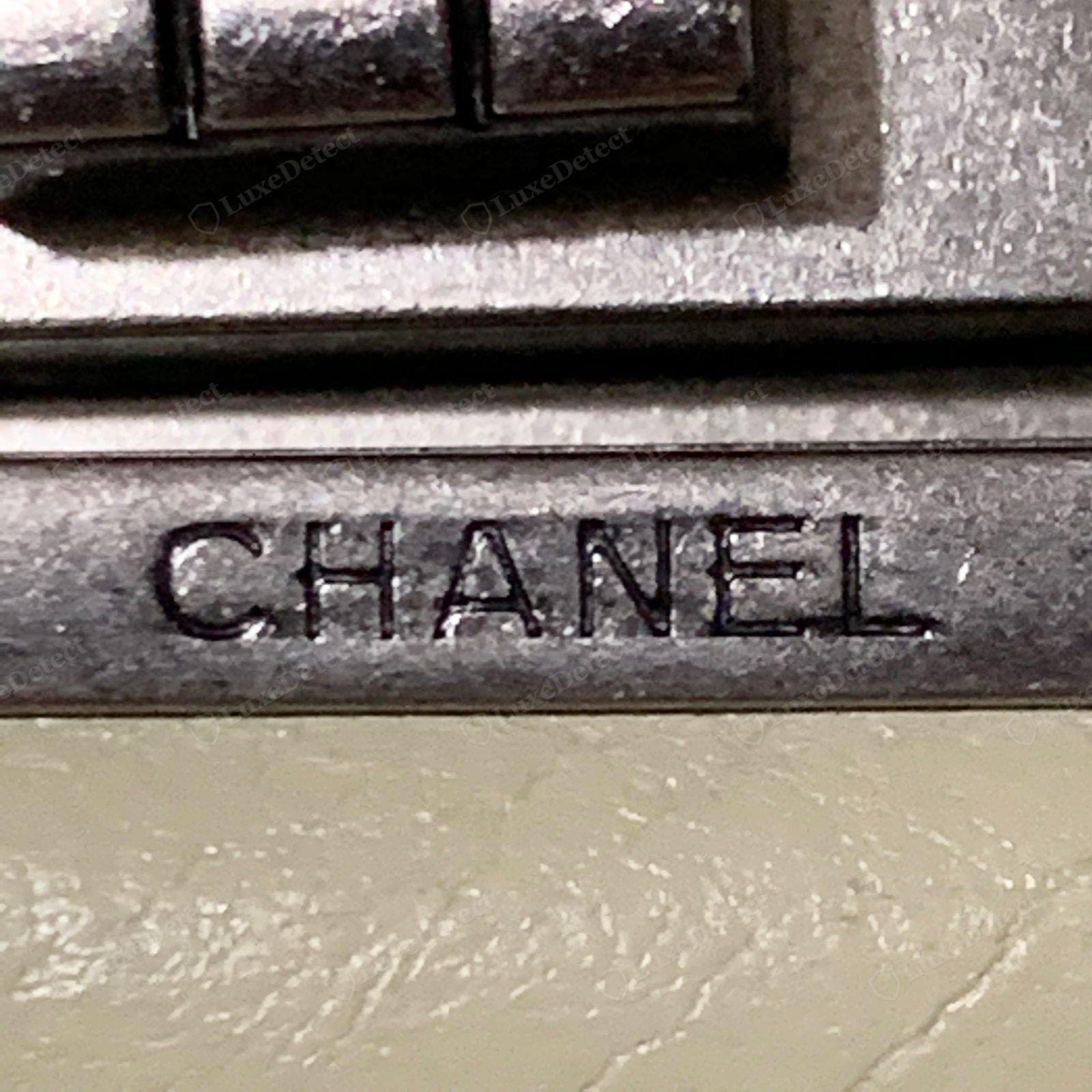Counterfeit Chanel hardware engraving — a shallow, uneven, or wrong-font "CHANEL", or the engraving missing entirely