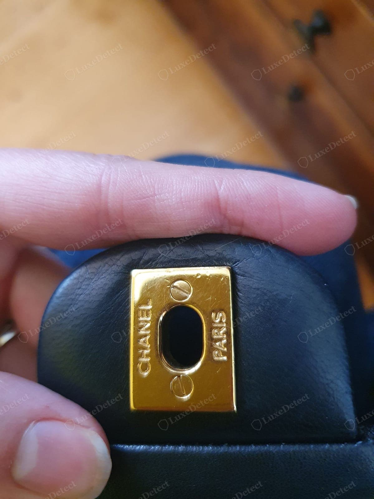 Genuine Chanel hardware engraving — "CHANEL" cut deep and even on the clasp back plate, crisp letterforms