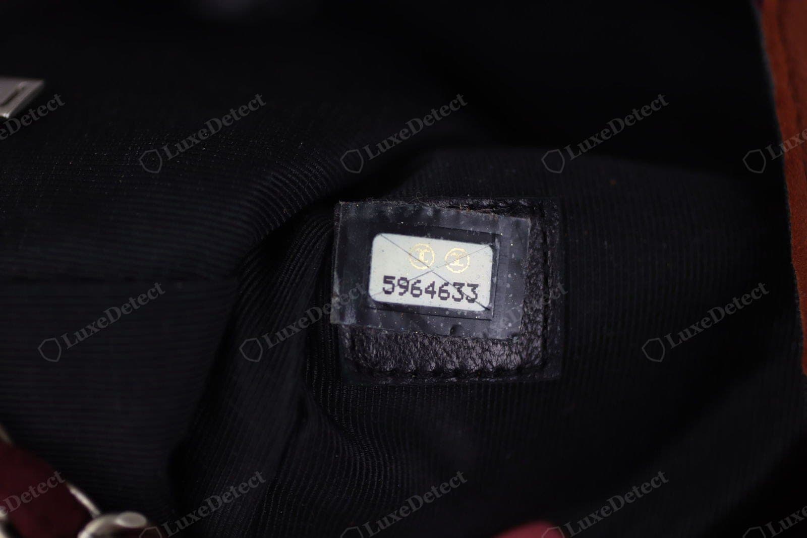 Genuine Chanel hologram sticker — "CHANEL" repeating and shifting colour across the foil, clean-cut edges, seated flat in the pocket
