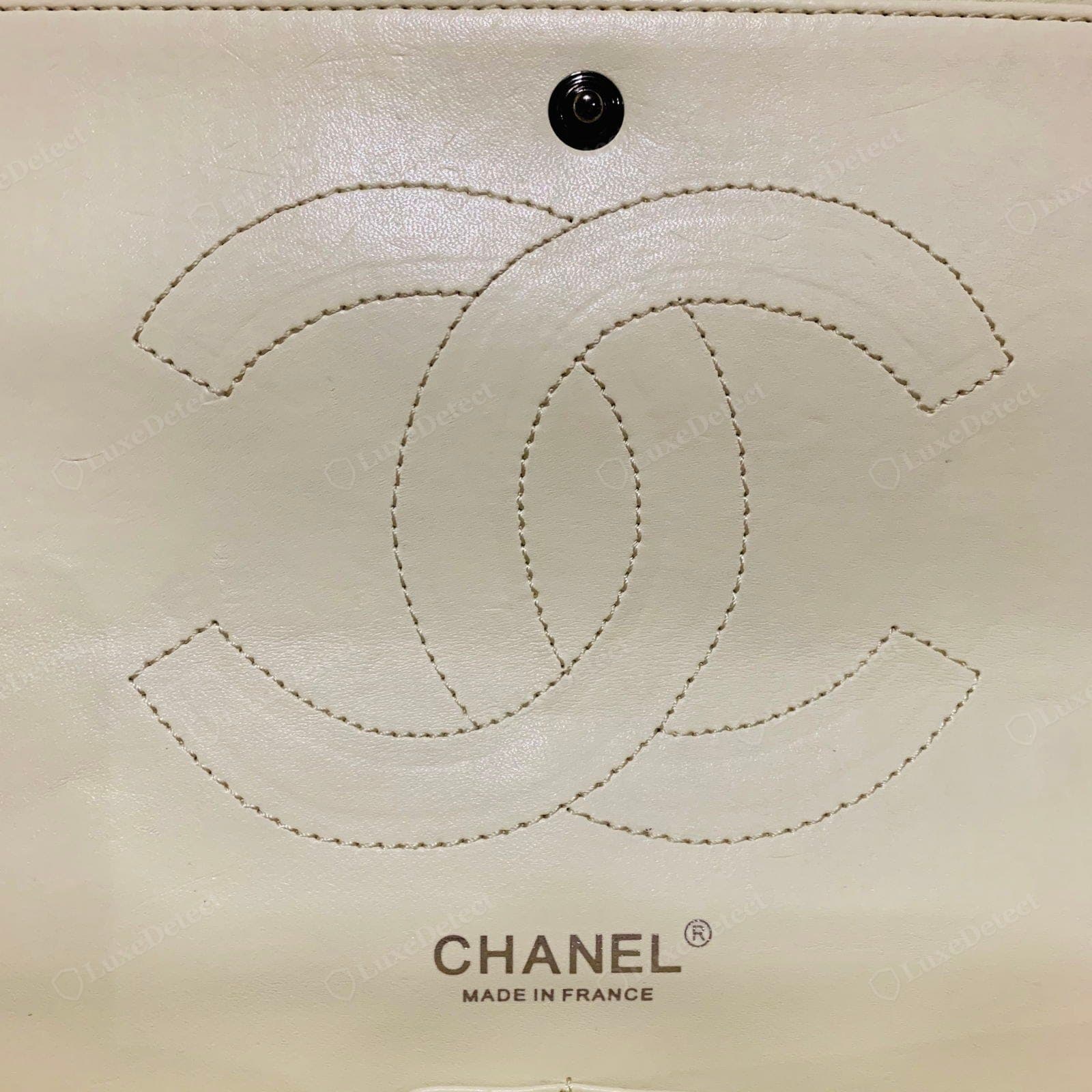 Counterfeit Chanel interior — a synthetic or sticky lining, the interior stamp in a wrong font or crooked, loose threads
