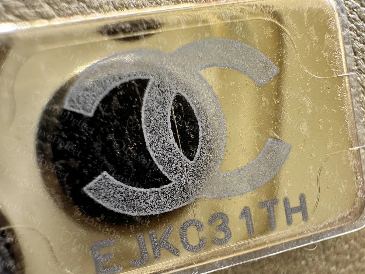 Genuine Mini Flap serial plate stuck in the lining: a rectangular gold plate with a CC logo above an eight-character code, under a clear protective film