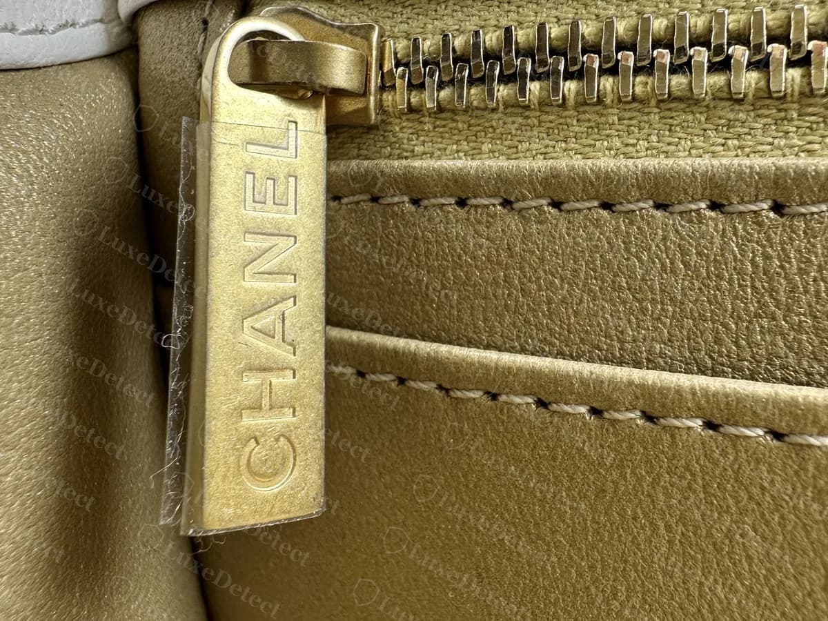 Genuine Mini Flap interior zip pocket pull in matte gold metal, engraved CHANEL down its length