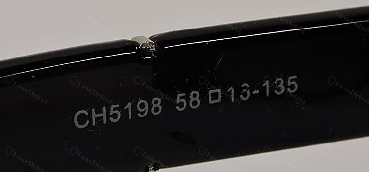Interior de la patilla falso de Chanel: una secuencia mucho más corta, "CH5198 58▫16-135", sin símbolos ©/®, sin código de color y sin marca de categoría del lente, y con un guion donde el formato original usa un espacio