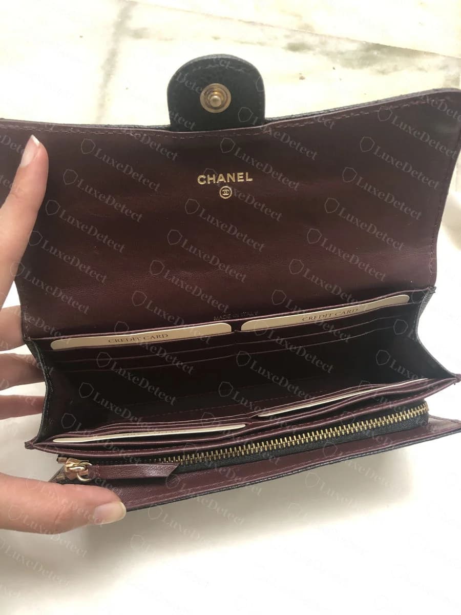Counterfeit Chanel wallet interior — a similarly placed gold CHANEL and CC stamp with credit card slot labeling, illustrating how closely this element is now reproduced