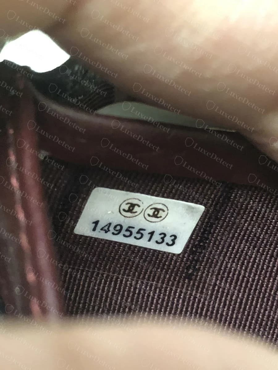 Counterfeit Chanel wallet serial sticker — a similarly formatted two-CC oval sticker with an 8-digit number, showing how closely the sticker's printed format is now replicated