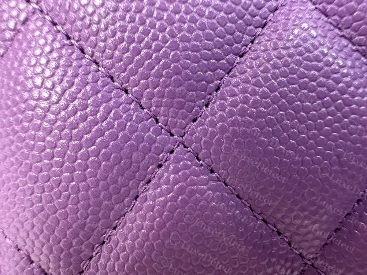 Close-up of genuine purple caviar leather on a Chanel WOC: evenly pebbled grain and diamond quilting with the stitching lines meeting cleanly at the crossing