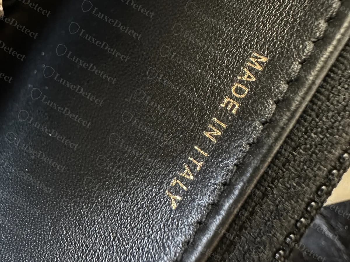Genuine Chanel WOC interior edge stamped MADE IN ITALY in gold on black leather, beside the zip pocket