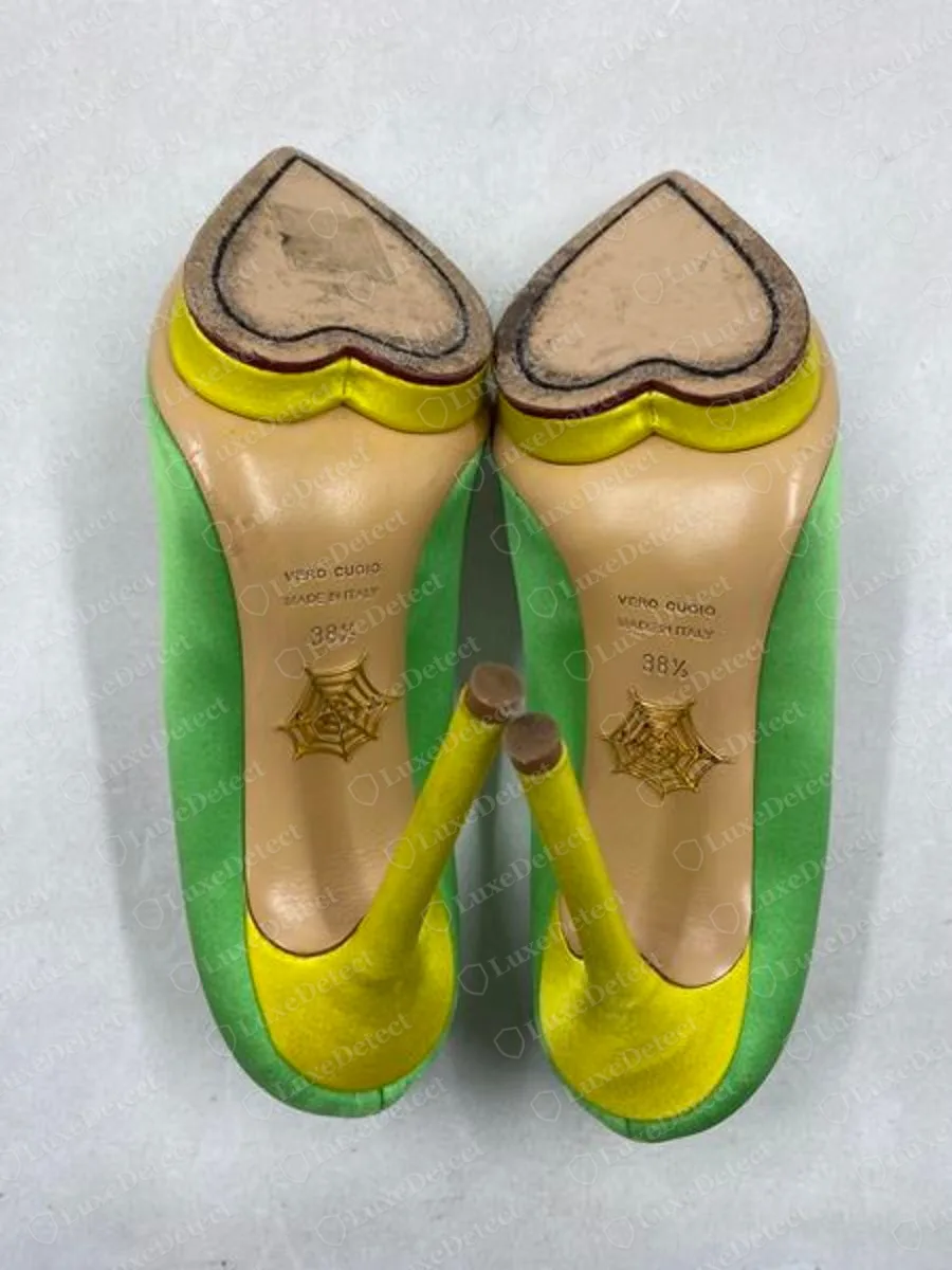 Echte grüne Charlotte-Olympia-Satin-Plateau-Pumps von unten gesehen, mit herzförmigen Absatzflecken, dem gestapelten Sohlenstempel und einem goldenen Netzemblem auf jeder Sohle
