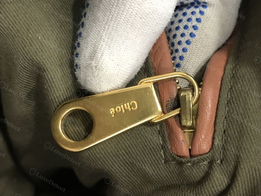 Authentic Chloé zipper pull — "Chloé" engraved cleanly and centered on the gold pull tab