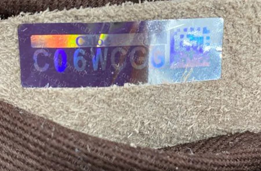 Hologram sticker from a confirmed fake Marcie: holographic finish, a six-character code and a QR-style square, stuck on the suede back of the serial tag