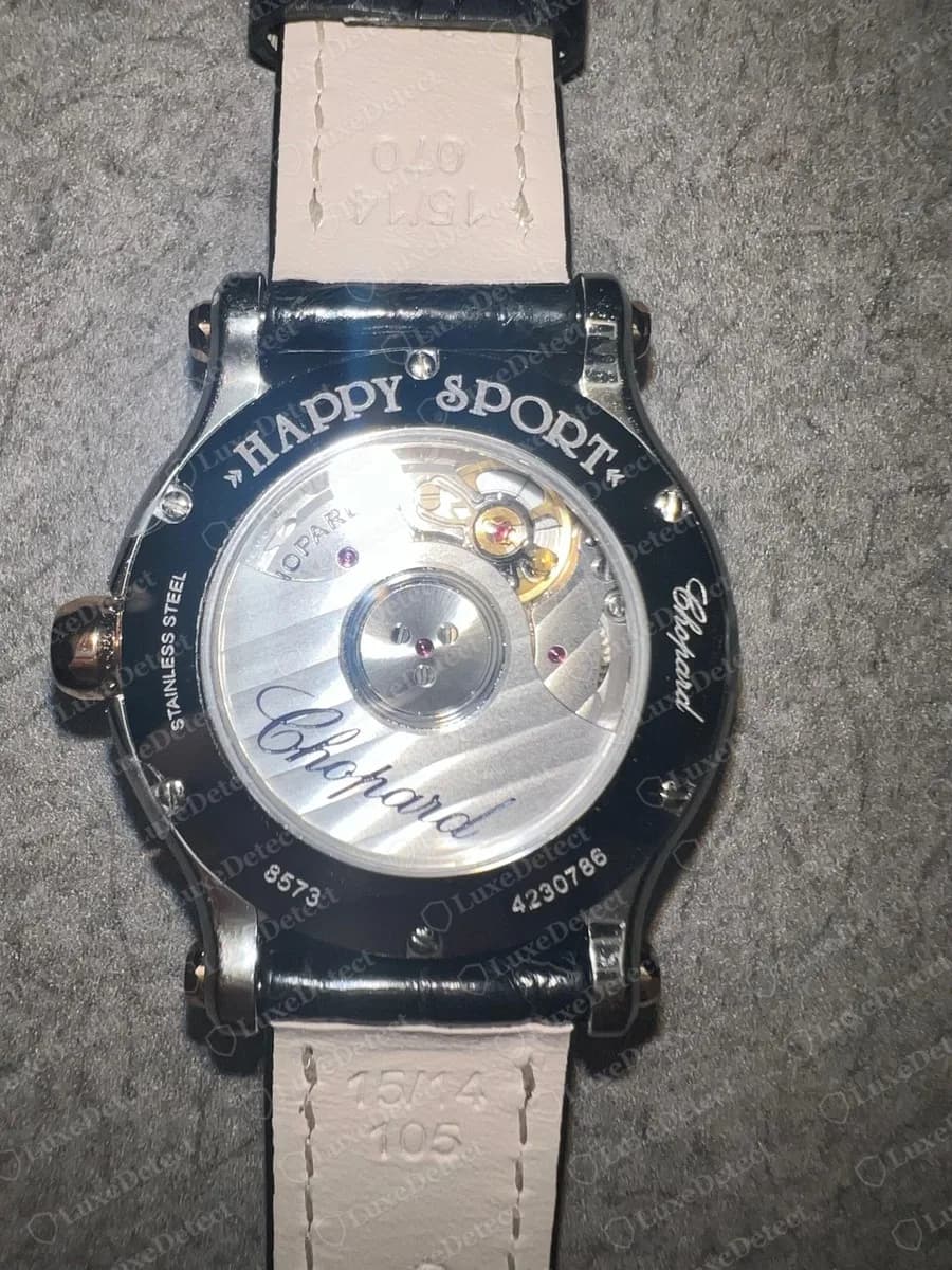 Echter Chopard-Happy-Sport-Gehäuseboden: HAPPY SPORT oben um den Ring graviert, STAINLESS STEEL und Chopard-Schriftzug an den Seiten, 8573 und 4230786 unten, Sichtboden mit Blick auf das Werk und einen Chopard-Rotor, Bandfutter gestempelt mit 15/14 und 105