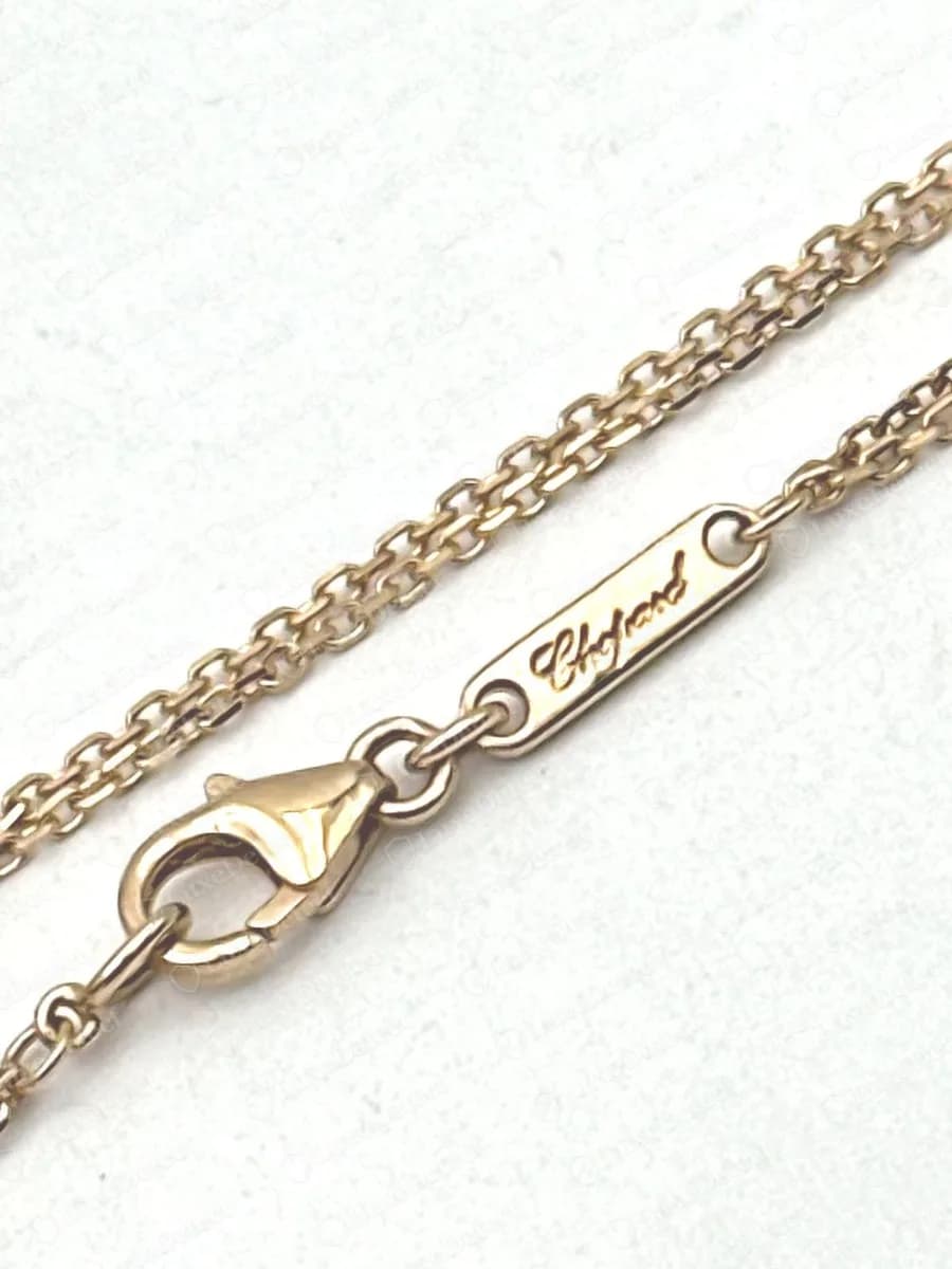 Echte roségoldene Chopard-Happy-Spirit-Anhängerkette mit einem kleinen rechteckigen Plättchen, graviert mit dem Chopard-Schriftzug, neben dem Karabinerverschluss