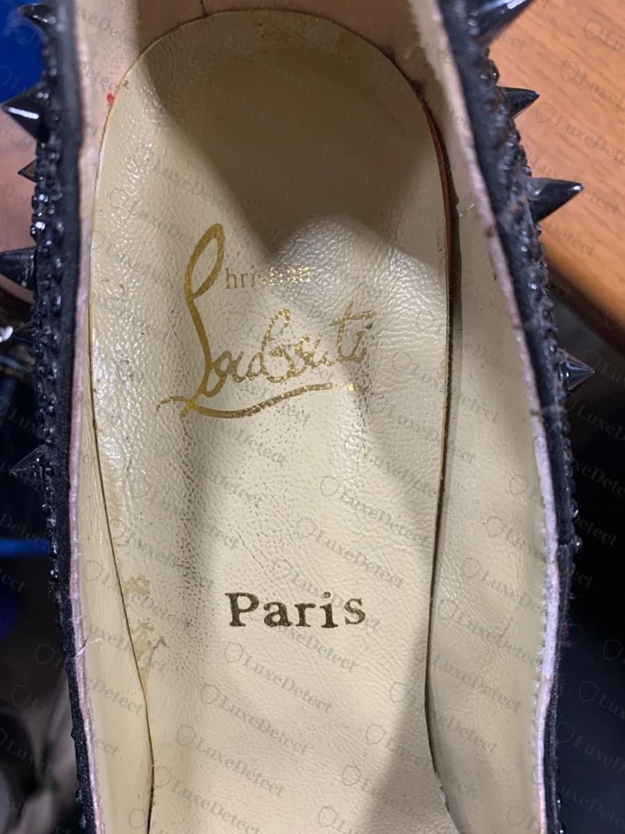Innensohle eines bestätigt gefälschten Spike-Pumps aus unserem Archiv: Die goldene Schrift ist missgebildet, "Christian" zu einem unleserlichen Fleck geschrumpft und der Nachname bildet keine sauberen Buchstaben, über einem korrekt geschriebenen "Paris"