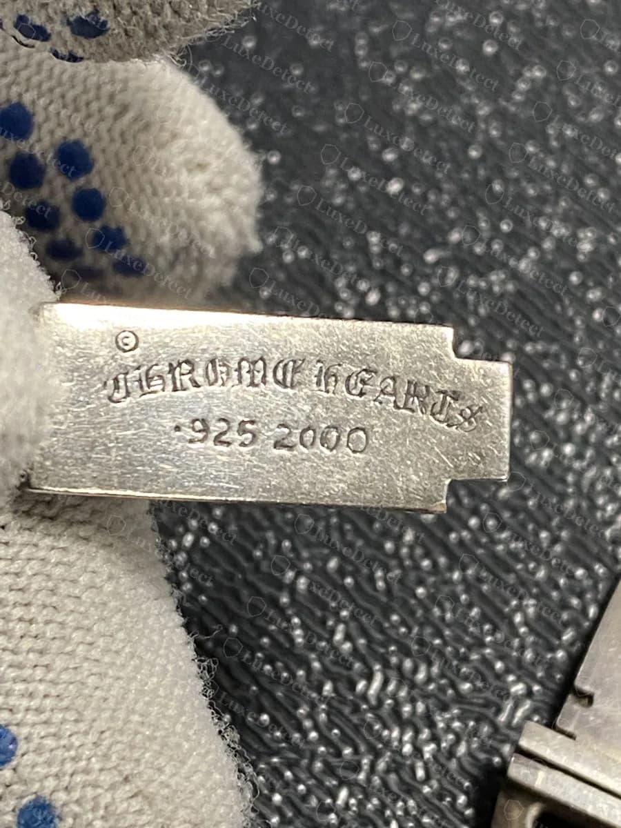 Authentic: the reverse of a genuine Chrome Hearts mini ID plate, a small ©, "CHROME HEARTS" in fine blackletter and ".925 2000", each character cleanly separated