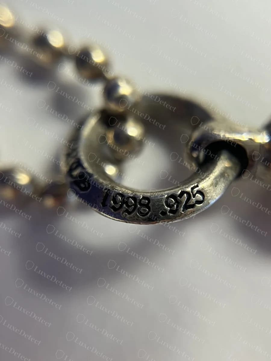 Contraffatto: un anello di giunzione punzonato su una collana ball chain Chrome Hearts falsa, con “1998 .925” in lettere convincenti, a dimostrazione che i falsi copiano anche questa parte