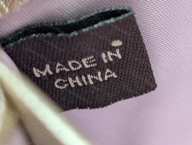 Cartera Coach antigua: etiqueta de origen de tela cosida, en mayúsculas, con una pequeña marca después de IN