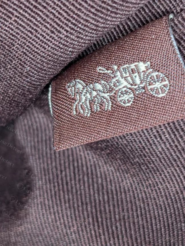 Wristlet Coach moderno: etiqueta tejida con el caballo y el carruaje cosida en la costura del forro